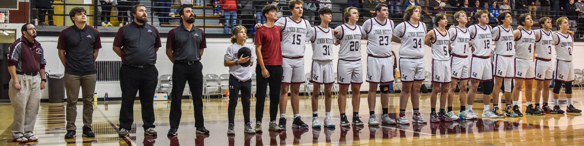The LI Boys Basketball team lined up on the court for the National Anthem at a home game. 
